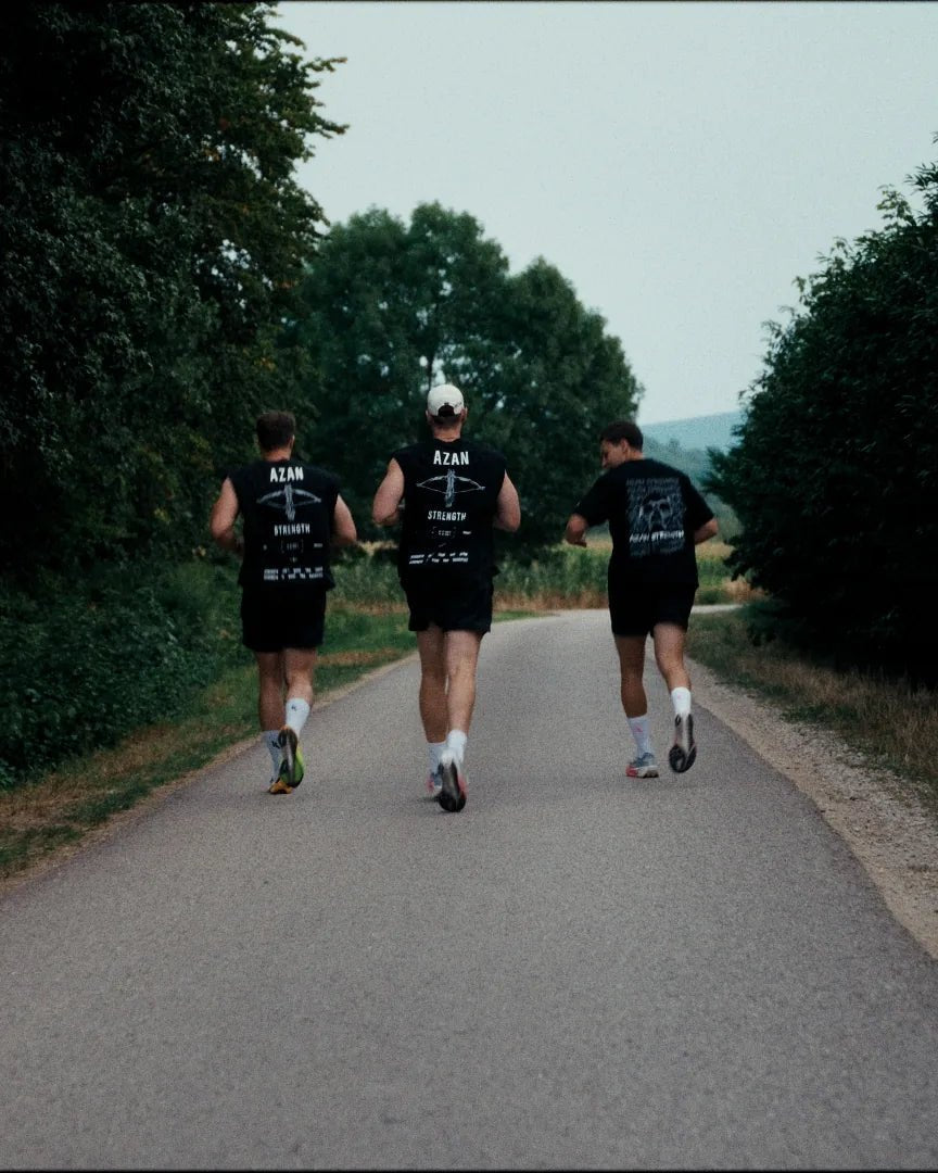 Drei Läufer im AZAN Tanktop auf einem Feldweg in der Dämmerung